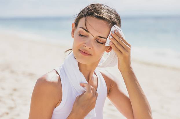 healthy woman wipe out her sweat with towel after workout