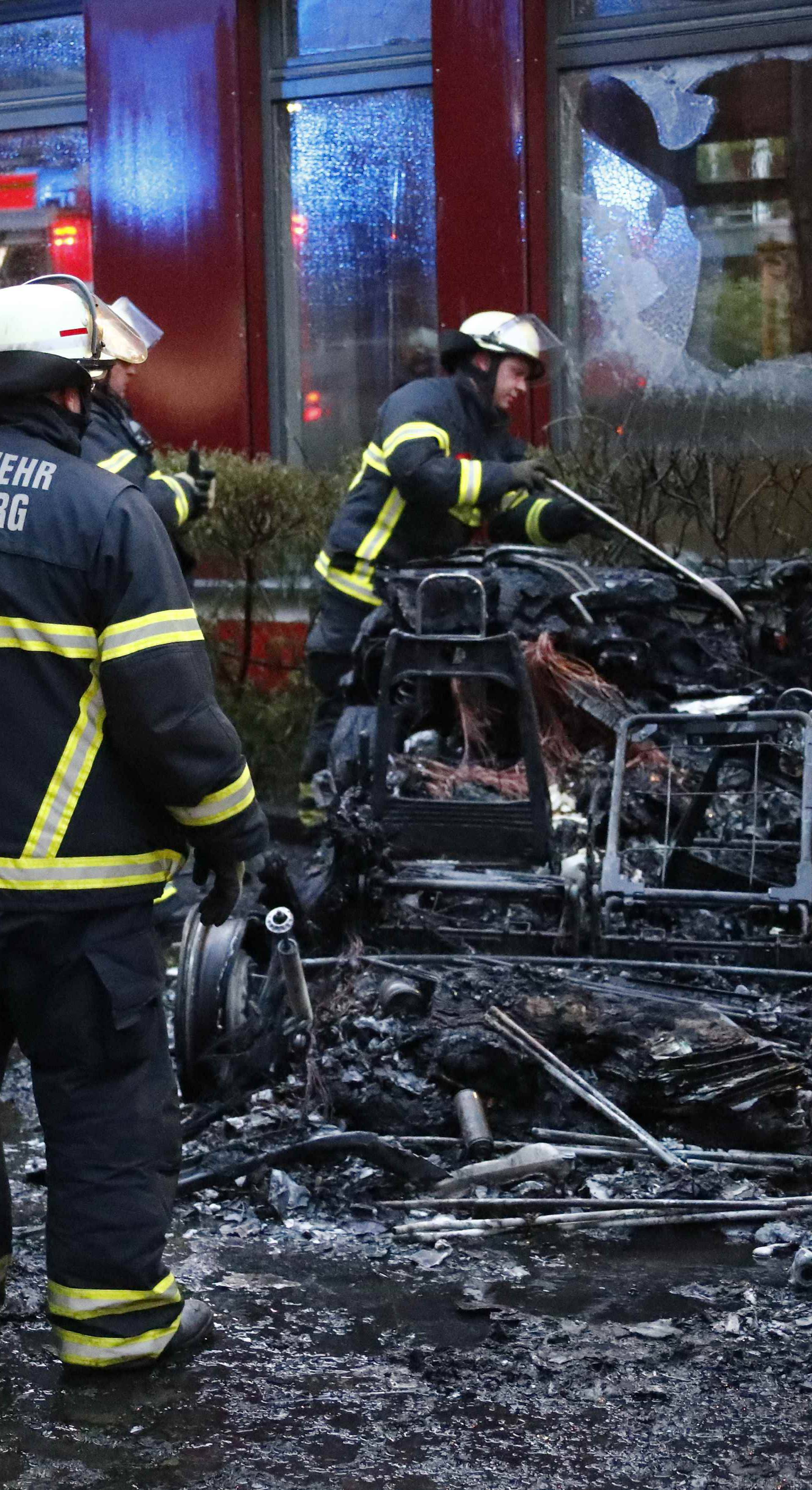 Firefighters inspect burnt out vehicles during the demonstrations during the G20 summit in Hamburg
