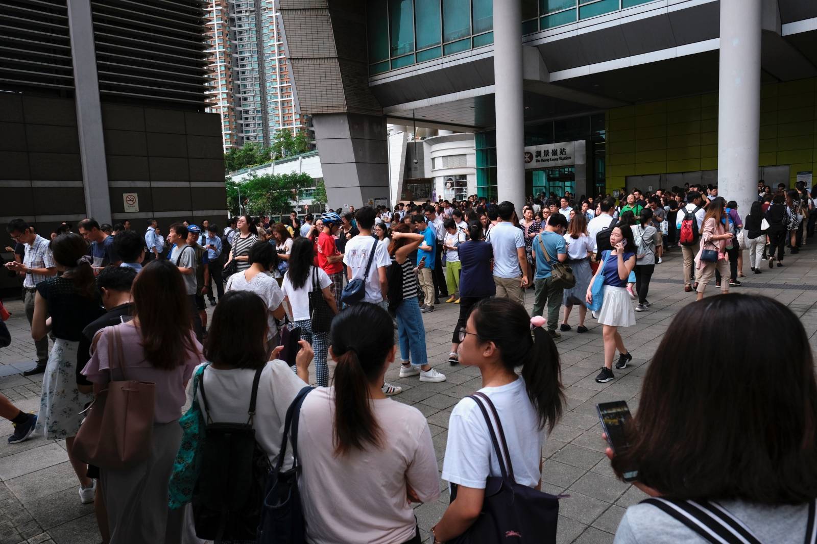 Passengers queue up for shuttle buses as anti-extradition bill demonstrators block the Mass Transit Railway (MTR) train service at a station in Hong Kong