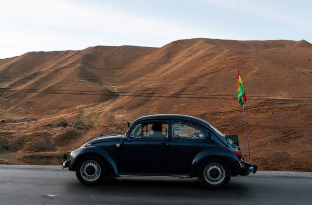 Bolivian Volkswagen Beetle fans drive through Cordillera Real mountain range towards the Amazon