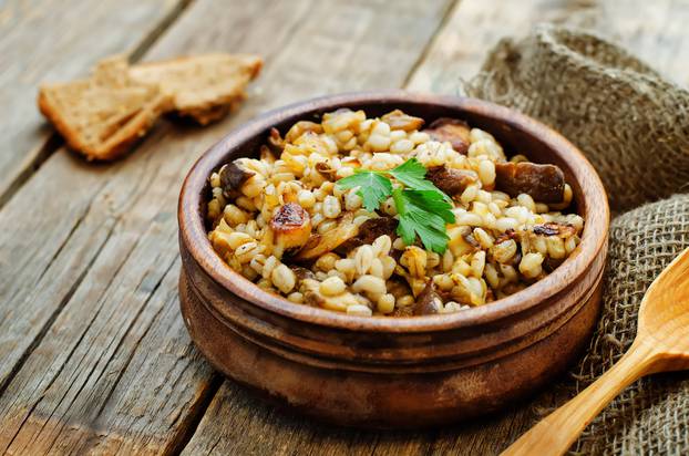 Barley,Porridge,With,Mushrooms,On,A,Dark,Wood,Background.,Tinting.