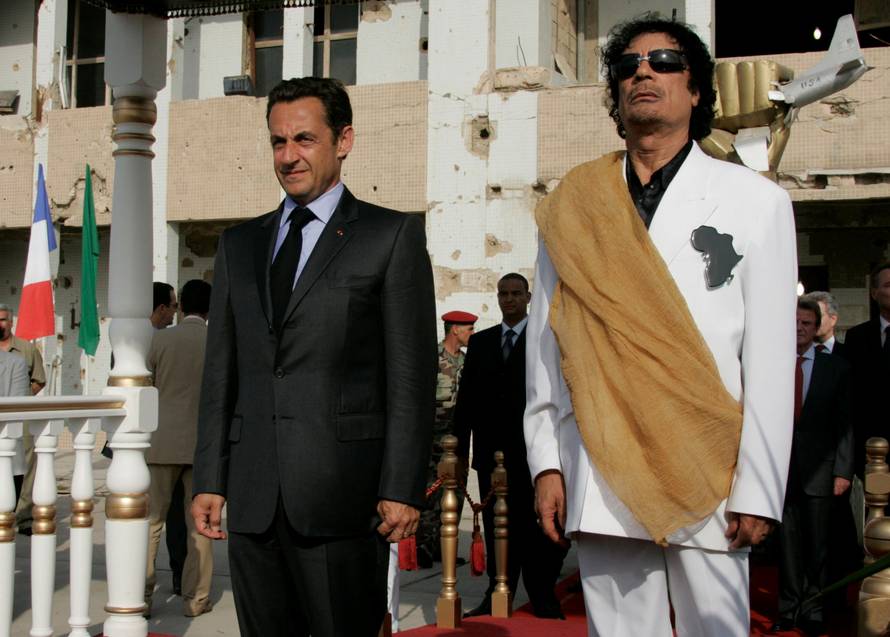 FILE PHOTO: Libya's President  Gaddafi and his counterpart from France Sarkozy listen to national anthems at Bab Azizia Palace in Tripoli