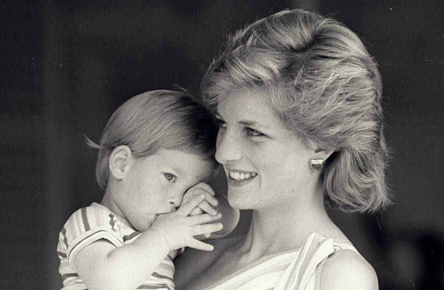 FILE PHOTO: Young Prince Harry tries to hide behind his mother Diana, Princess of Wales
