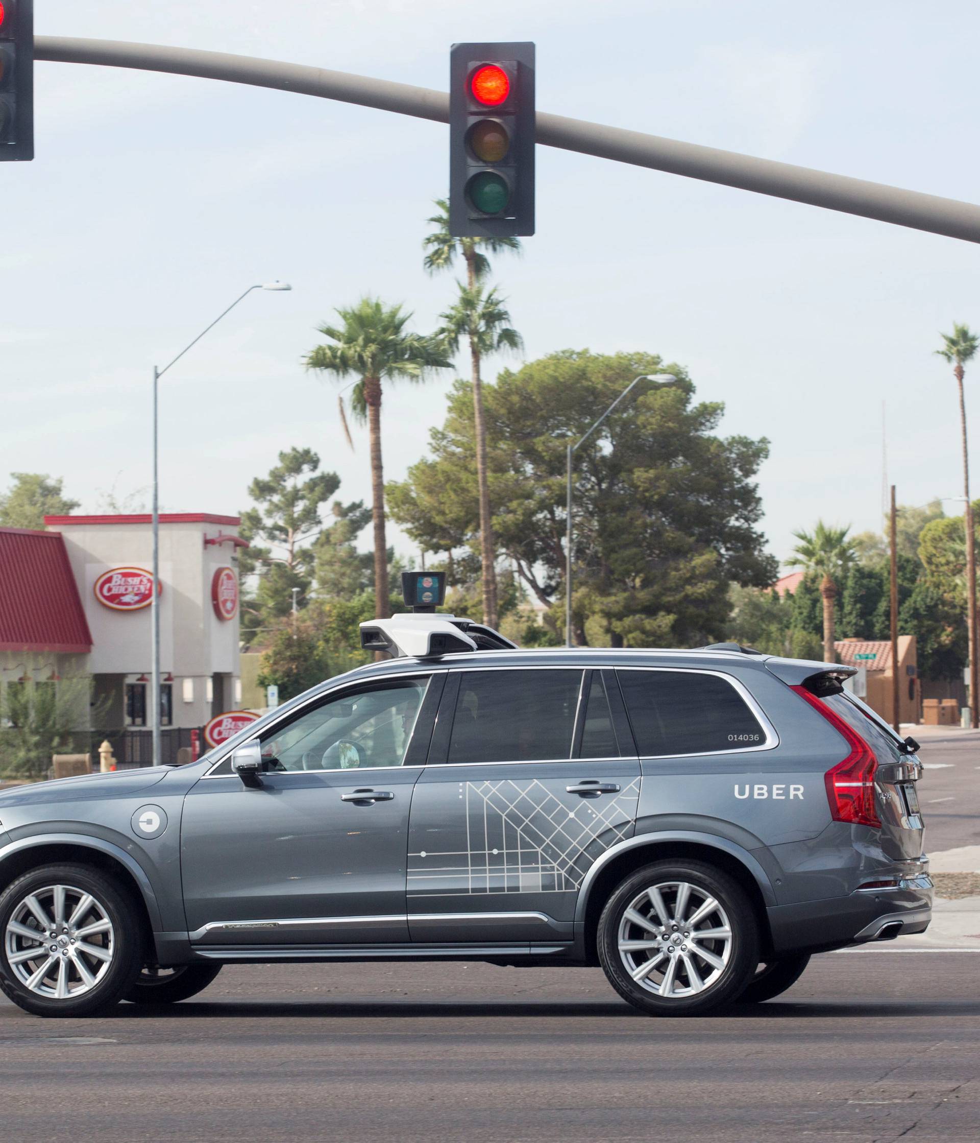 FILE PHOTO: A self driving Volvo vehicle, purchased by Uber, moves through an intersection in Scottsdale