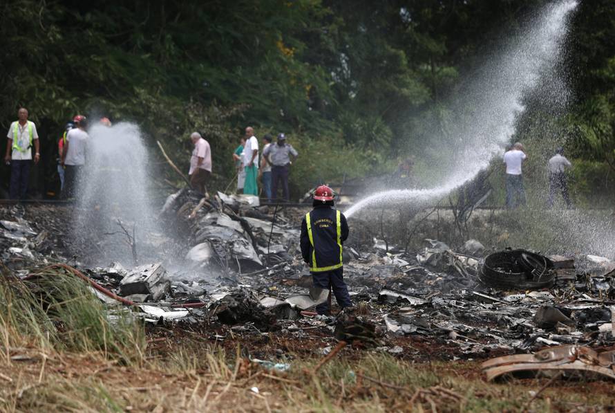 A fire fighter works in the wreckage of a Boeing 737 plane that crashed  in the agricultural area of Boyeros, some 20 km (12 miles) south of Havana on Friday shortly after taking off from Havana's main airport in Cuba