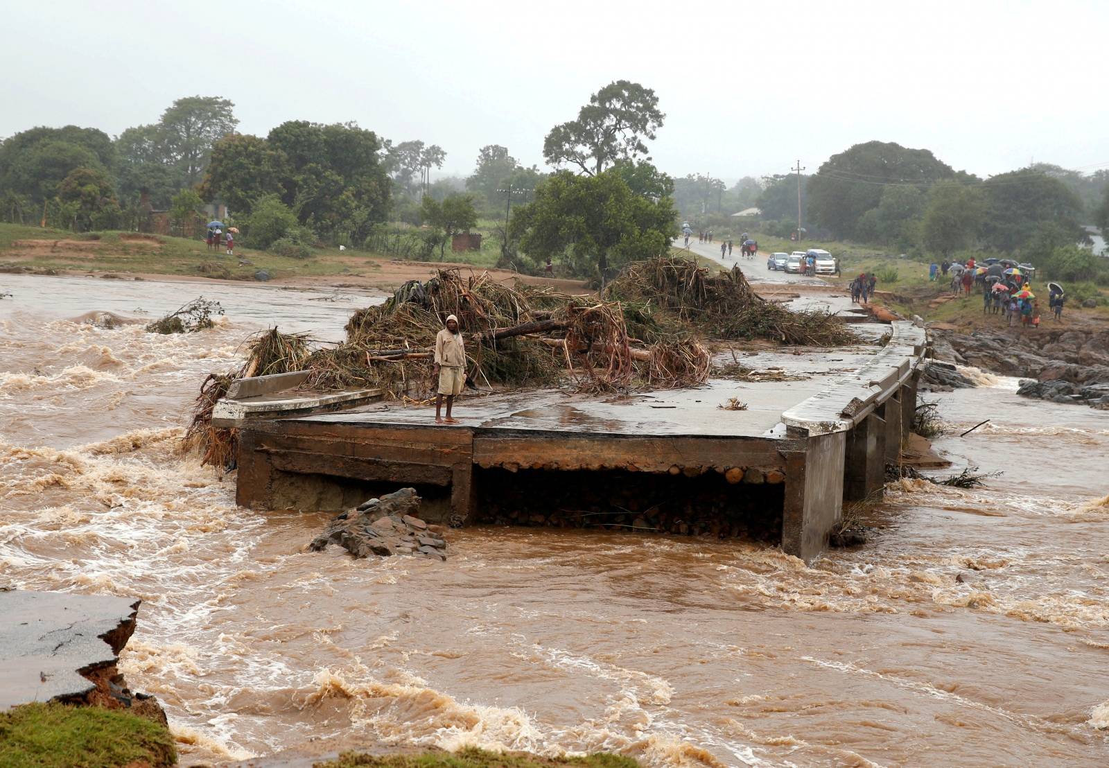 A man looks at a washed away bridge along Umvumvu river following Cyclone Idai in Chimanimani