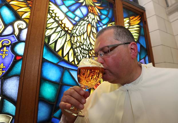Norbertine Father Karel tastes a Grimbergen beer, symbolised by a phoenix, in the courtyard of the Belgian Abbey of Grimbergen before announcing that the monks will return to brewing after a break of two centuries, in Grimbergen