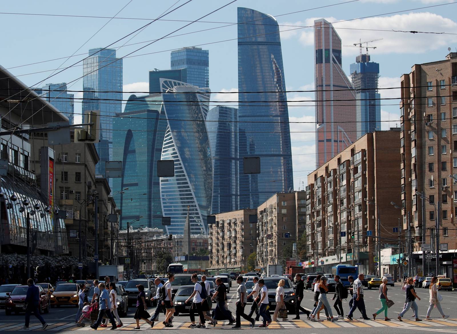 FILE PHOTO: Pedestrians cross the road as skyscrapers of the Moscow International Business Center, also known as "Moskva-City", are seen in the background in Moscow