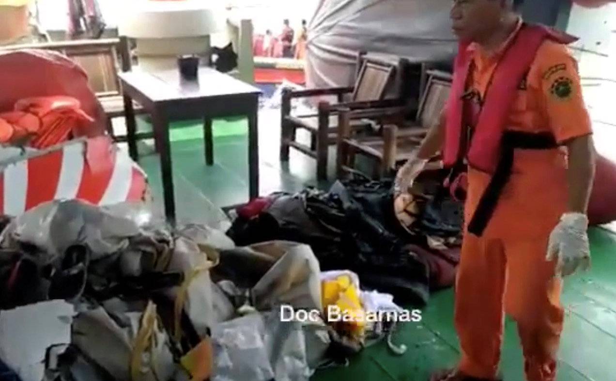 A Basarnas crew member gathers debris which are believed to be from Lion Air flight JT610, that took off from Jakarta and crashed into the sea