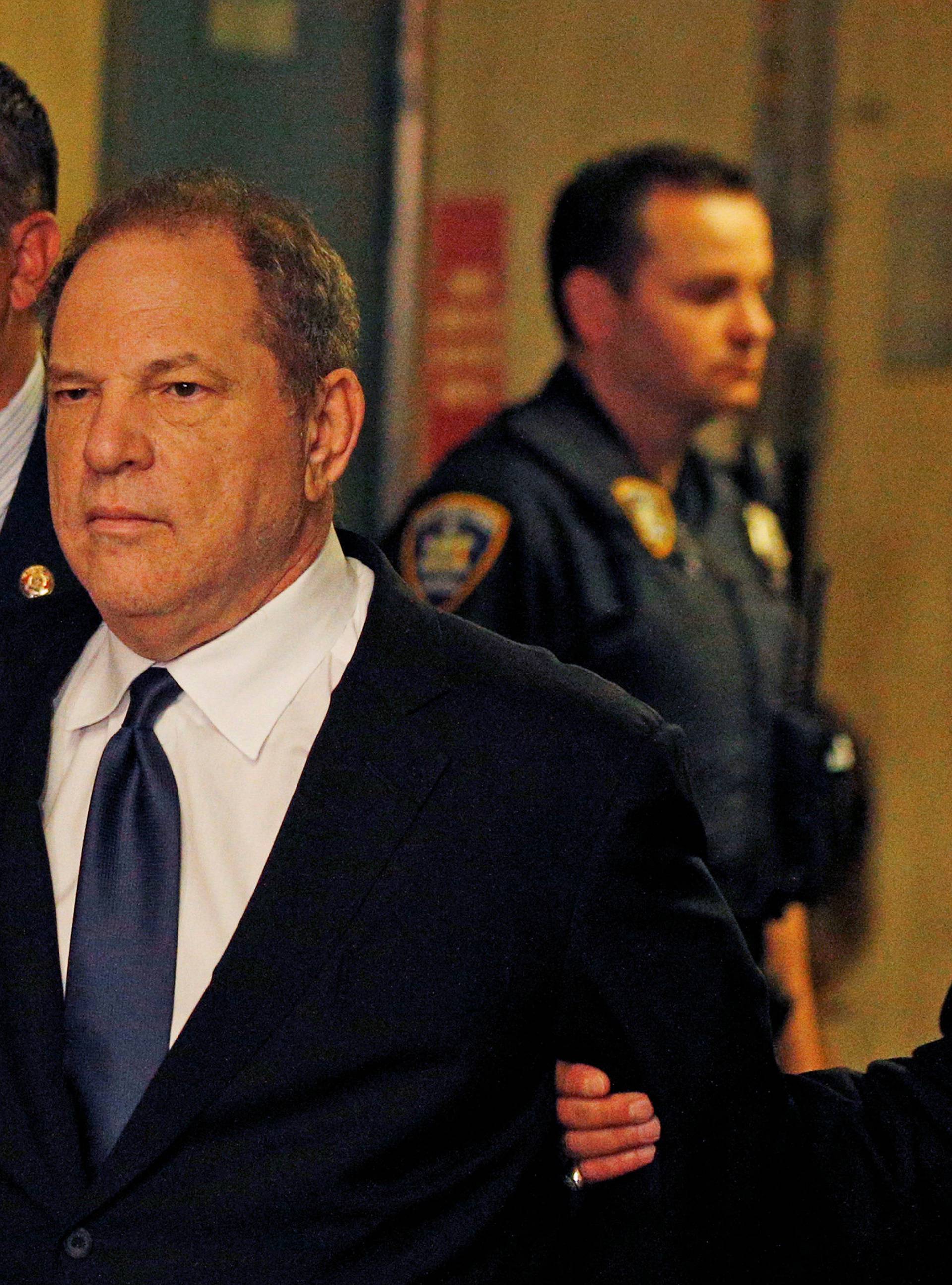 Film producer Harvey Weinstein is led handcuffed by police into his hearing at Manhattan Criminal Court