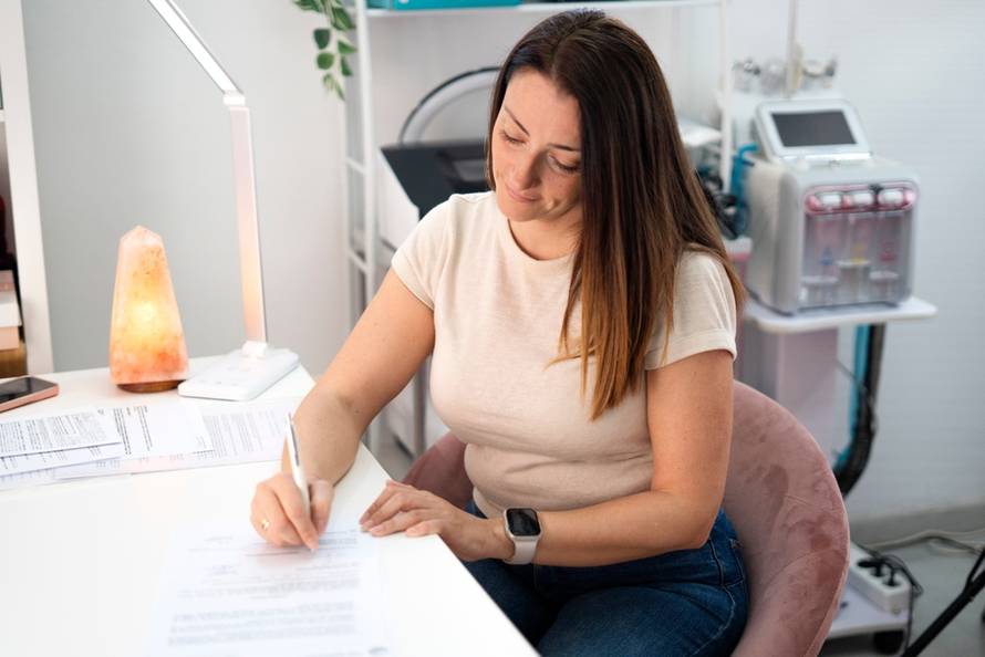 Beautician,Filling,Out,Documents,And,Signing,A,Contract,In,Her