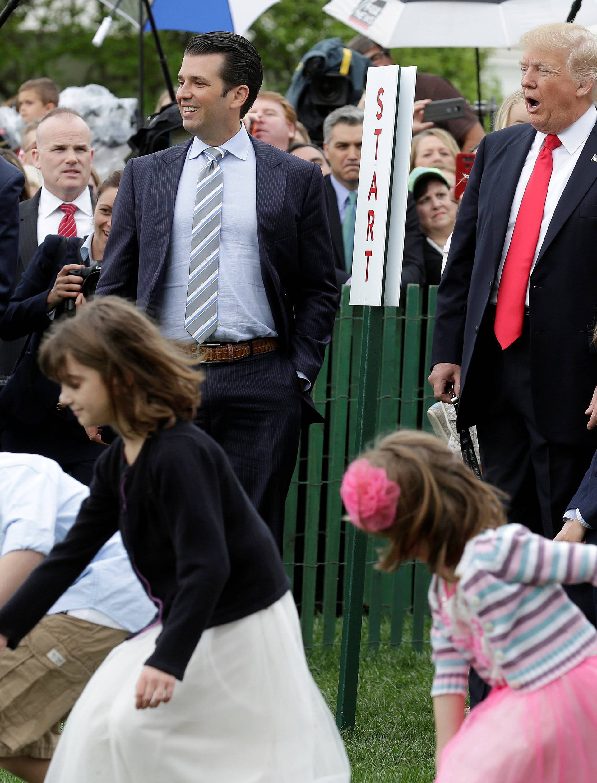 U.S. President Donald Trump and his son Donald Trump, Jr., watch children roll Easter Eggs at 139th annual White House Easter Egg Roll on the South Lawn of the White House in Washington