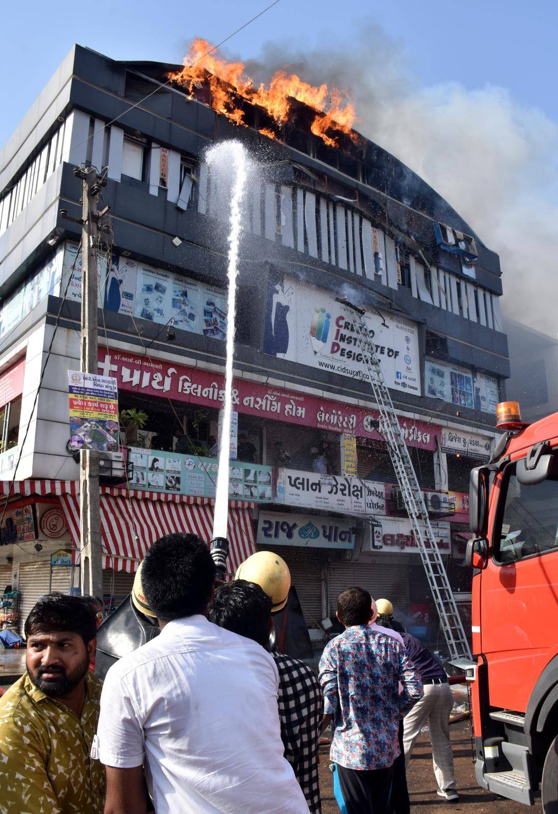 Firefighters douse a fire that broke out in a four-story commercial building in Surat