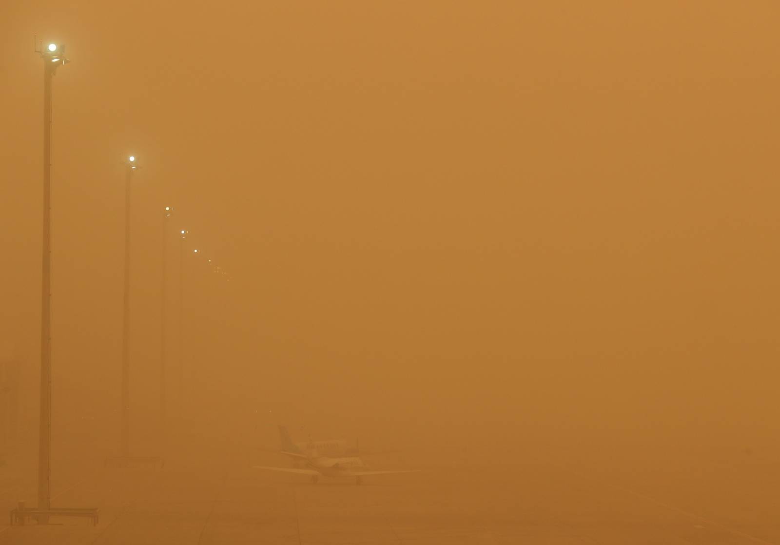 Planes are seen parked on the tarmac during a sandstorm blown over from North Africa known as "calima" at Las Palmas Airport