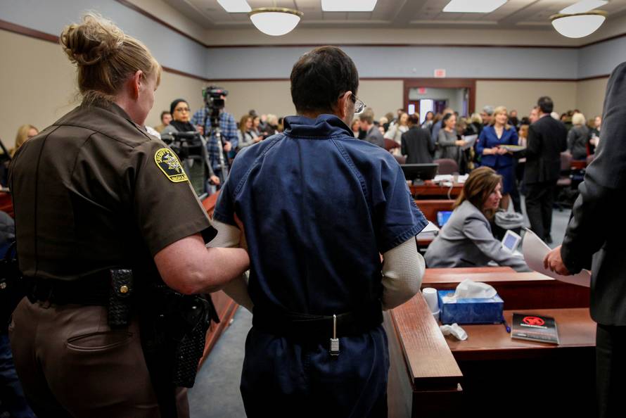 Larry Nassar, a former team USA Gymnastics doctor who pleaded guilty in November 2017 to sexual assault charges, is escorted by a court officer during his sentencing hearing in Lansing, Michigan