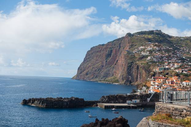 Beautiful landscape with a mountain, cliff, ocean and port in a