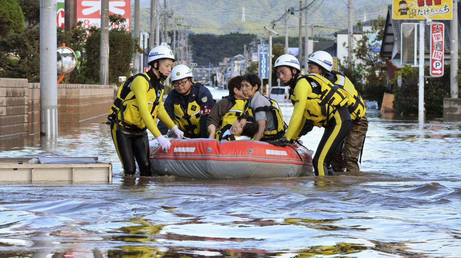 Local residents sit in a boat as they are rescued from a flooded residential area following Typhoon Hagibis in Iwaki