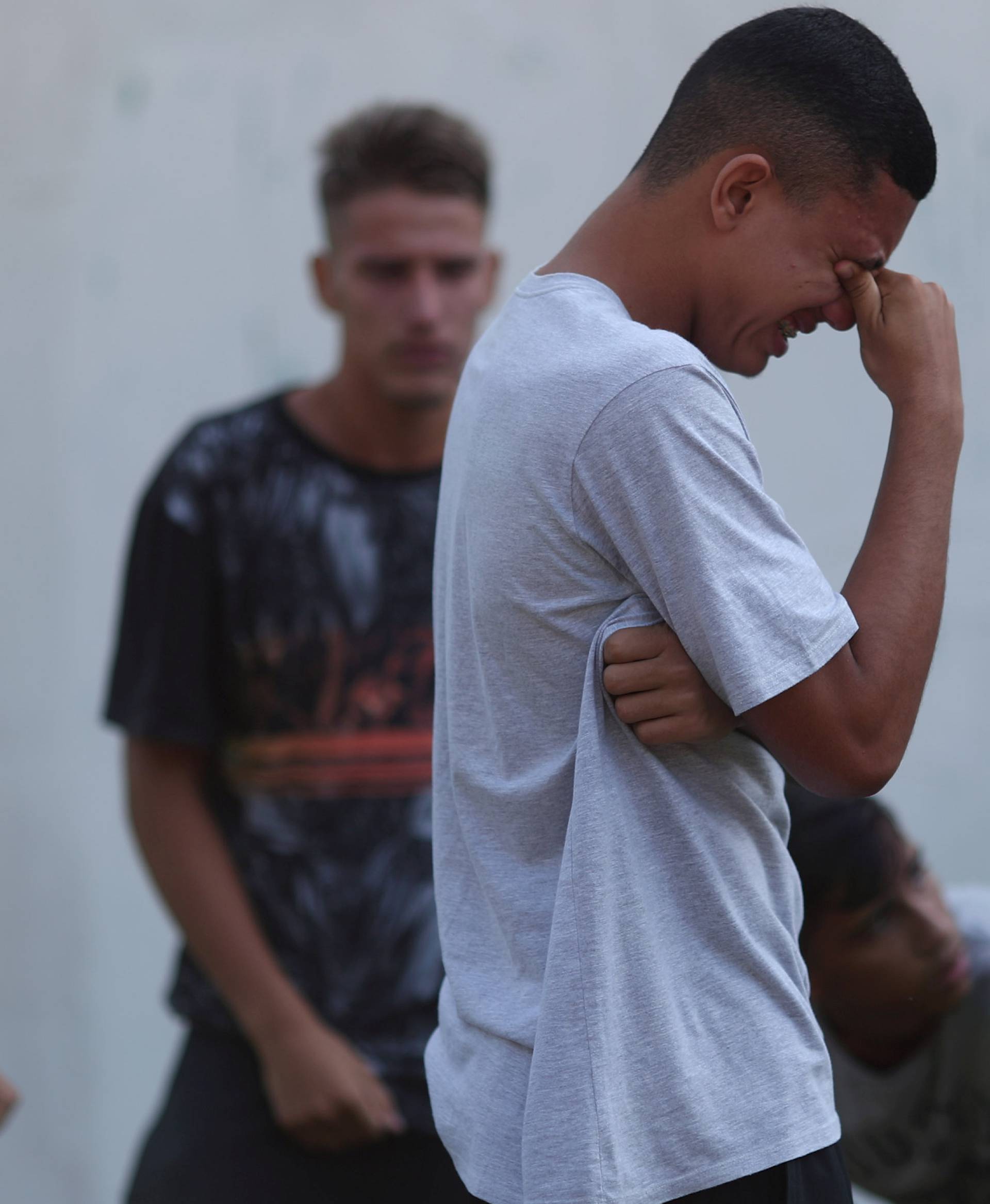 People wait for information in front of the training center of Rio's soccer club Flamengo, after a deadly fire in Rio de Janeiro