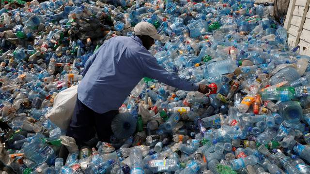 An employee sorts plastic bottles at the Weeco plastic recycling factory at the Athi River industrial zone near Nairobi