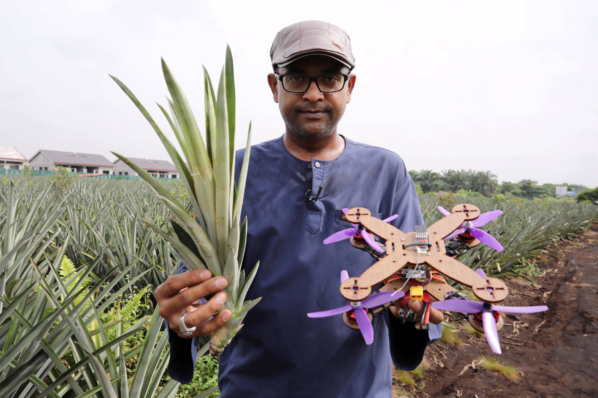 University Putra Malaysia professor Mohamed Thariq holds pineapple leaves and a drone partially made with pineapple stems, in Jenjarom