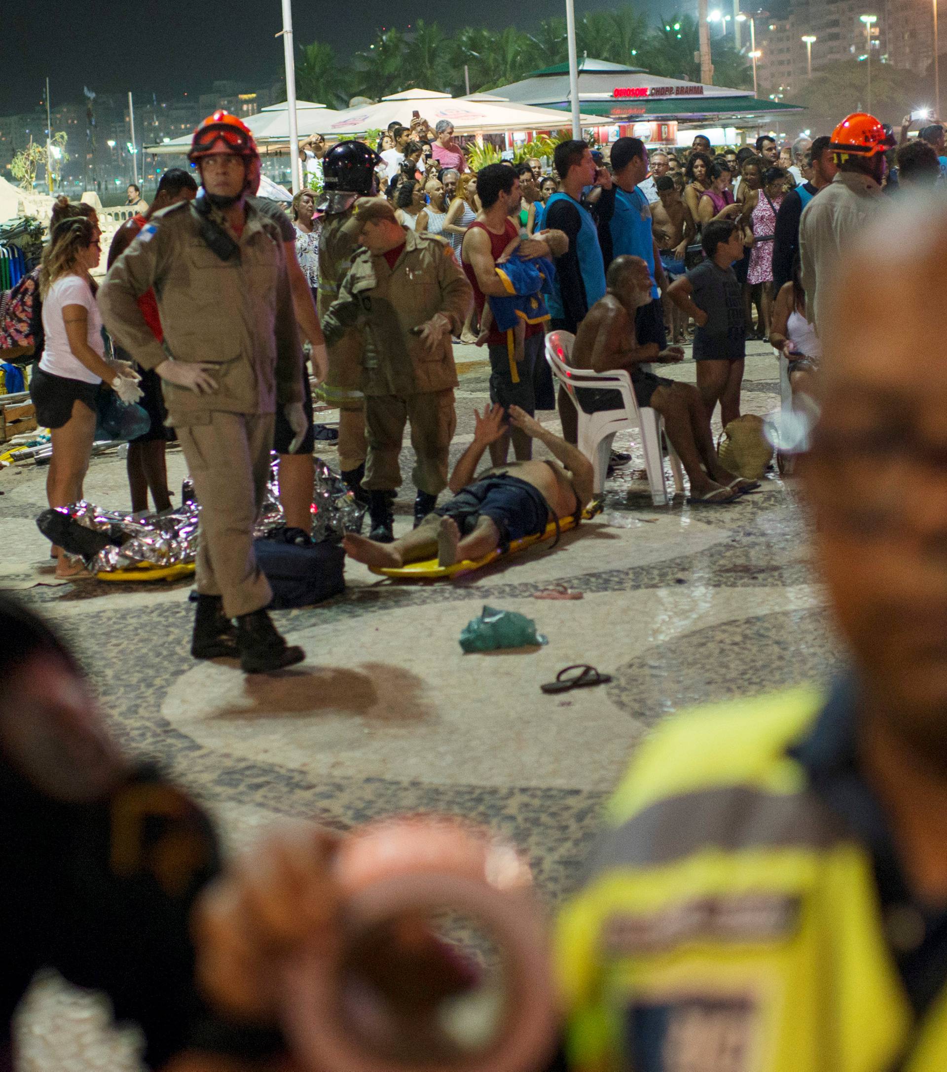 Paramedics help an injured after a vehicle ran over some people at Copacabana beach in Rio de Janeiro