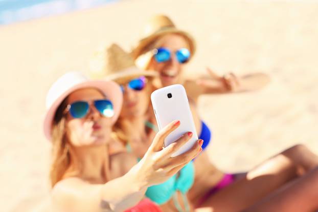 Group of friends taking selfie on the beach