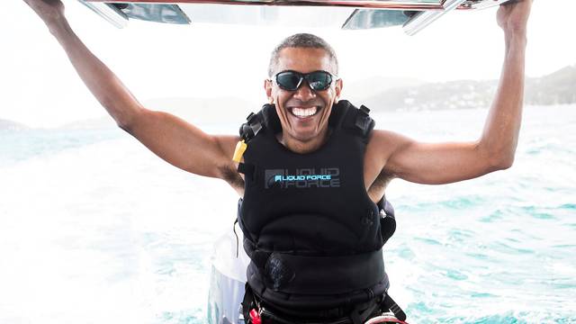 Former U.S. President Barack Obama sits on a boat during a kite surfing outing with British businessman Richard Branson during his holiday on Branson's Moskito island, in the British Virgin Islands, in a picture handed out by Virgin