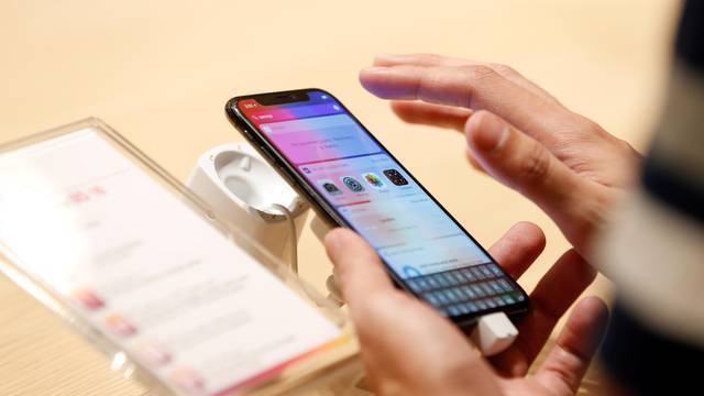 FILE PHOTO: A customer tests the features of the newly launched iPhone X at VIVA telecommunication store in Manama