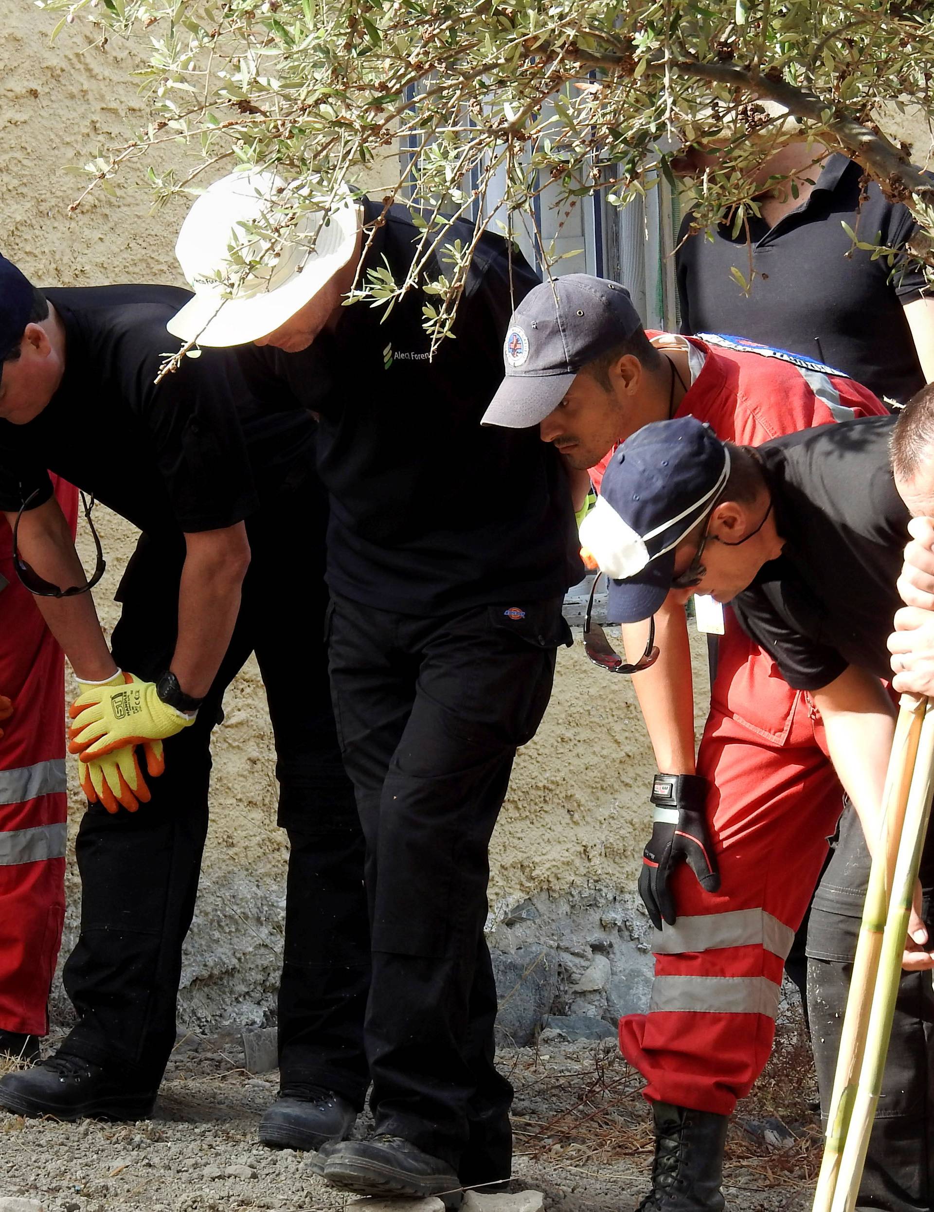 South Yorkshire police officers and members of the Greek rescue service (in red uniforms) investigate the ground before commencing excavating a site for Ben Needham, a 21 month old British toddler who went missing in 1991, on the island of Kos