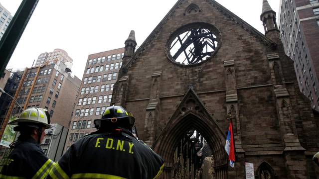 New York City firefighters (FDNY) stand in front of Manhattan's historic Serbian Orthodox Cathedral of Saint Sava following a fire in New York City
