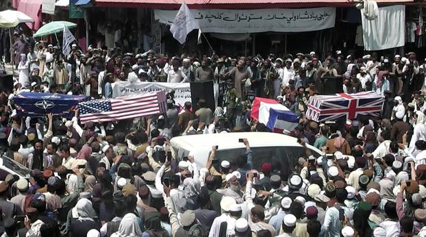 U.S. and NATO flags flank coffins at mock funeral held by Taliban