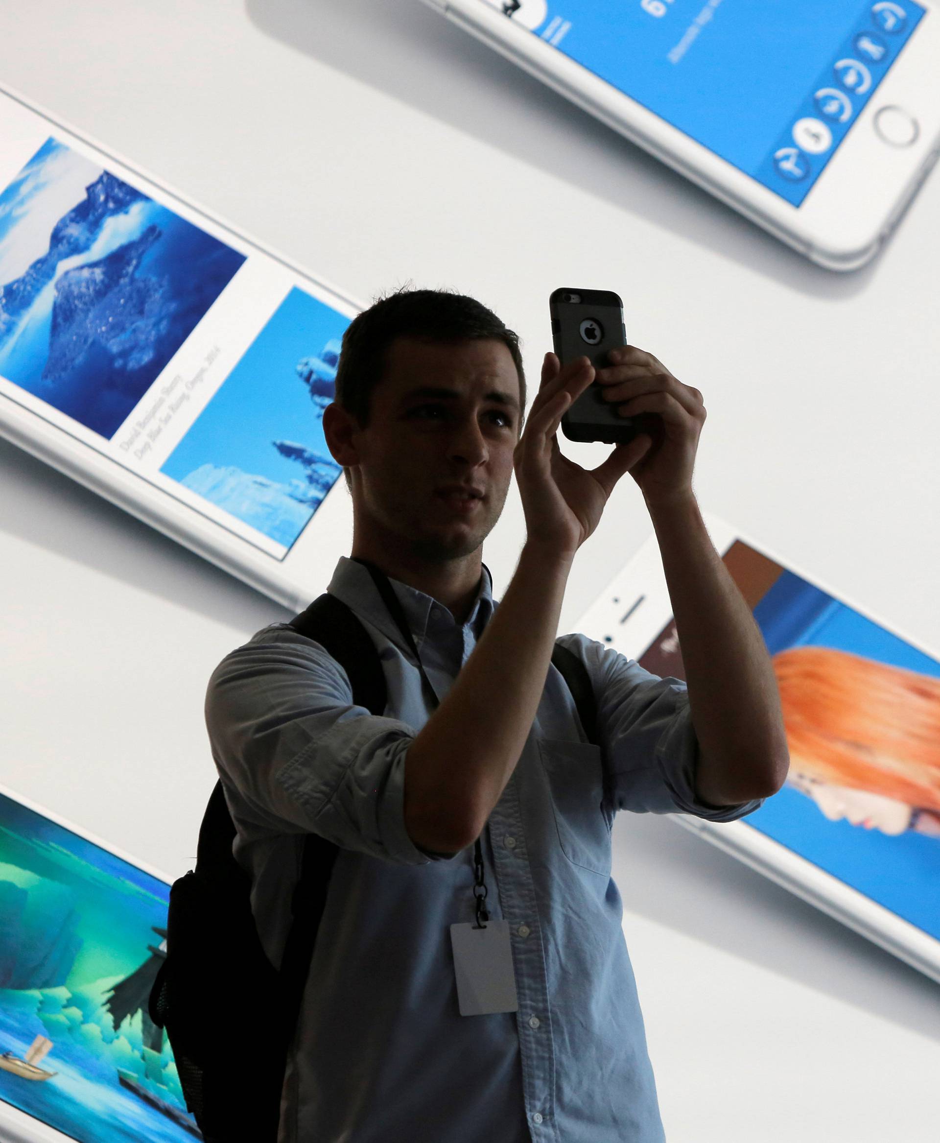FILE PHOTO: A man uses his iPhone during a preview event at the new Apple Store Williamsburg in Brooklyn, New York