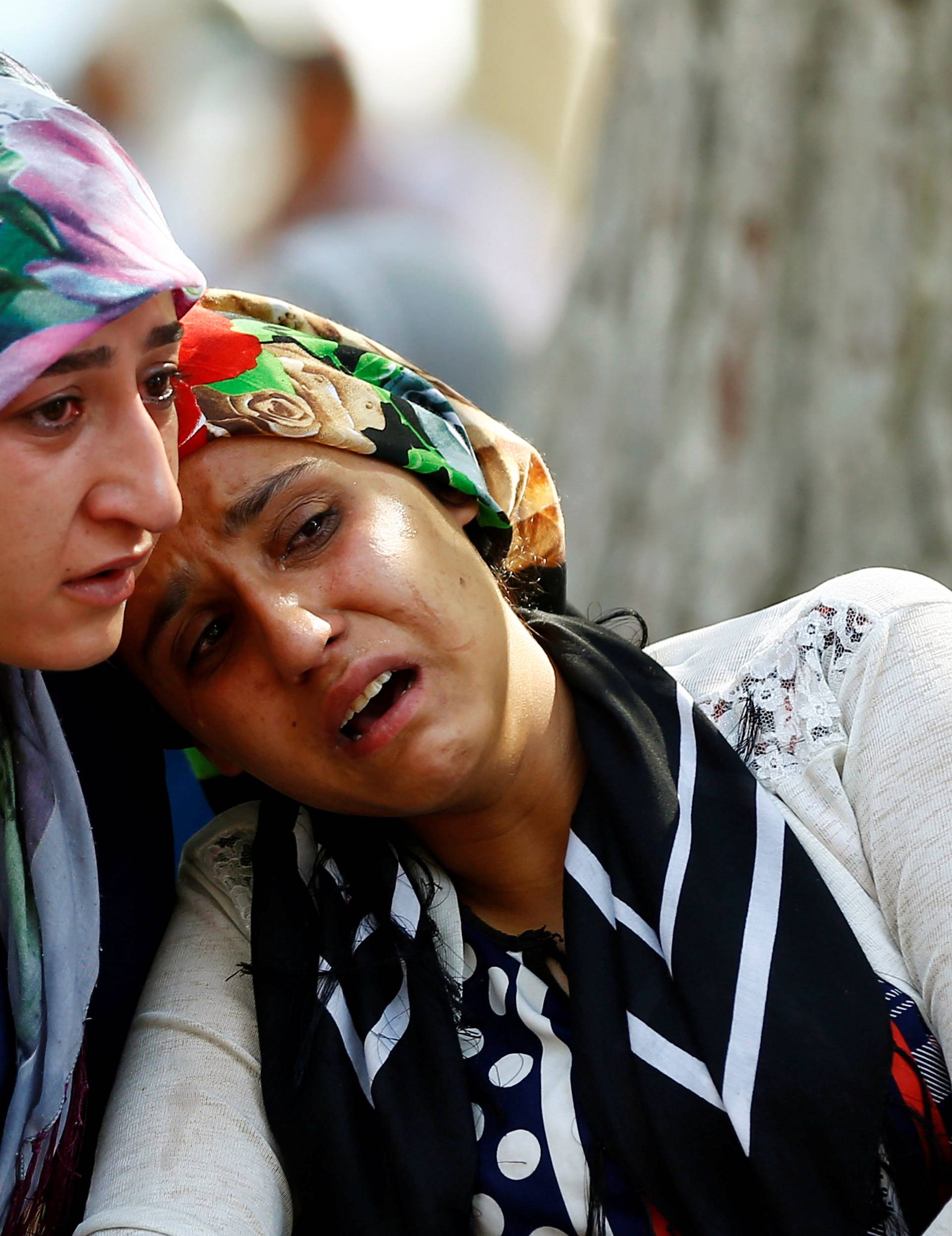 Women mourn as they wait in front of a hospital morgue in the Turkish city of Gaziantep, after a suspected bomber targeted a wedding celebration in the city, Turkey