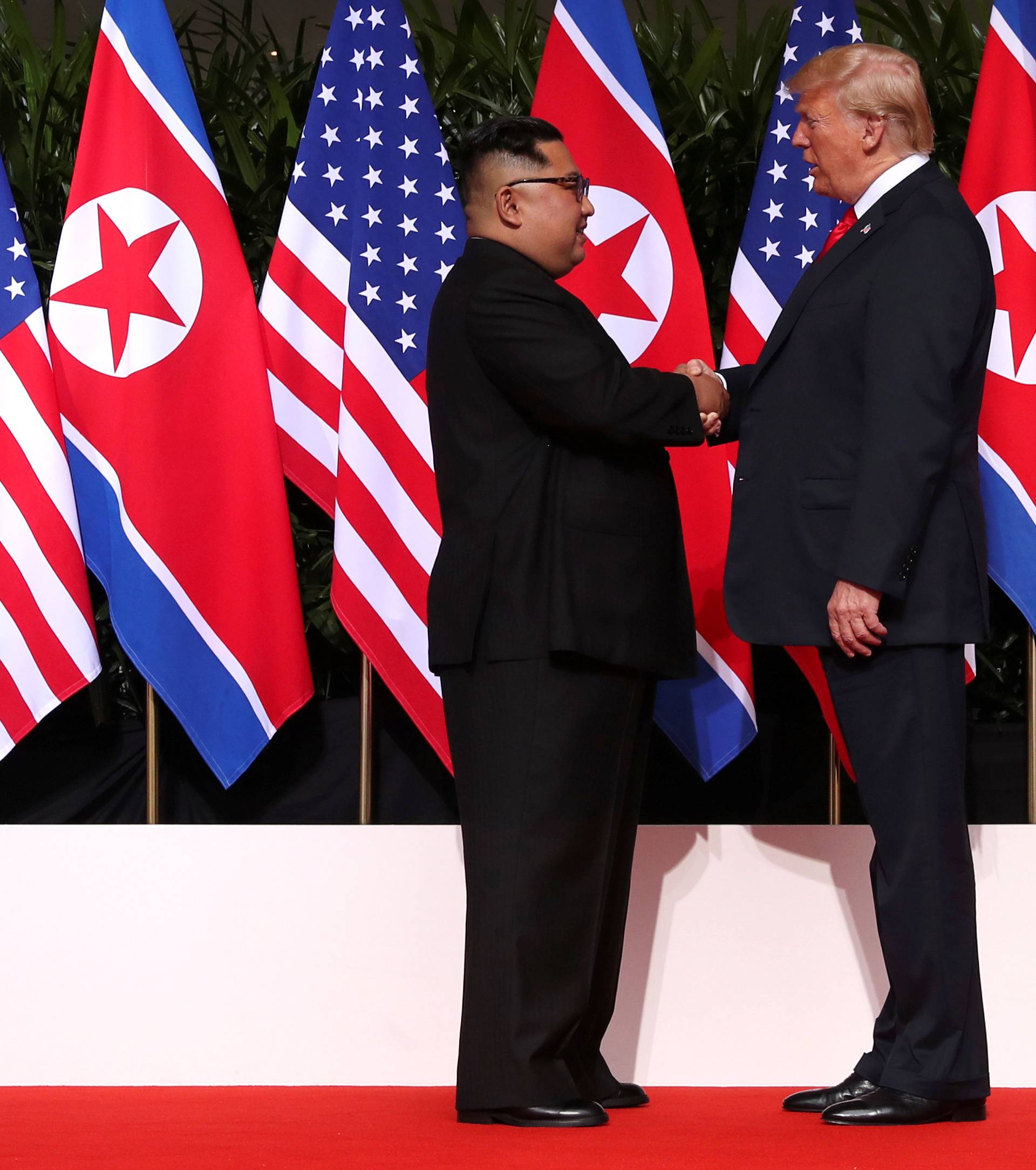 U.S. President Donald Trump and North Korea's leader Kim Jong Un shake hands during a summit at the Capella Hotel on the resort island of Sentosa, Singapore