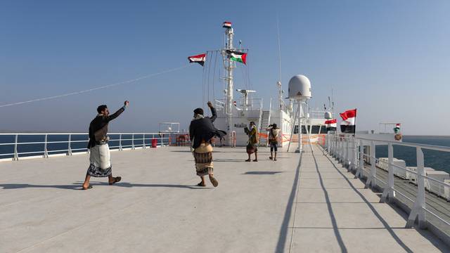People dance on the deck of the Galaxy Leader commercial ship, seized by Yemen's Houthis last month, off the coast of al-Salif