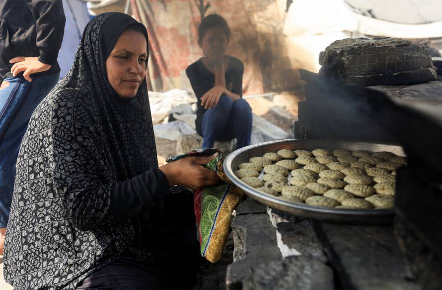 Palestinians, displaced by the Israeli military offensive, shelter in a tent camp, in Gaza City