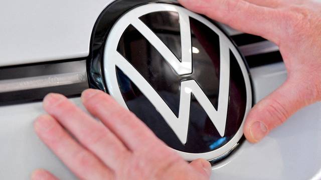 FILE PHOTO: An assembly line technician fixes a VW badge on a Volkswagen  ID.3 electric car