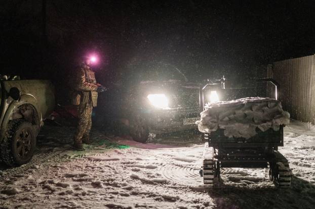 Ukrainian servicemen operate an unmanned ground vehicle fit for delivery missions on the frontline in Donetsk region