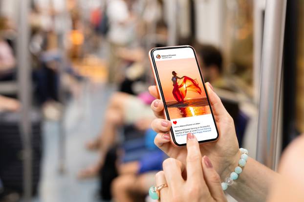 Woman,Riding,In,Metro,And,Viewing,Someone's,Photo,On,Mobile