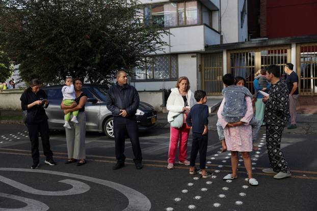 People gather outside a building following an earthquake in Bogota