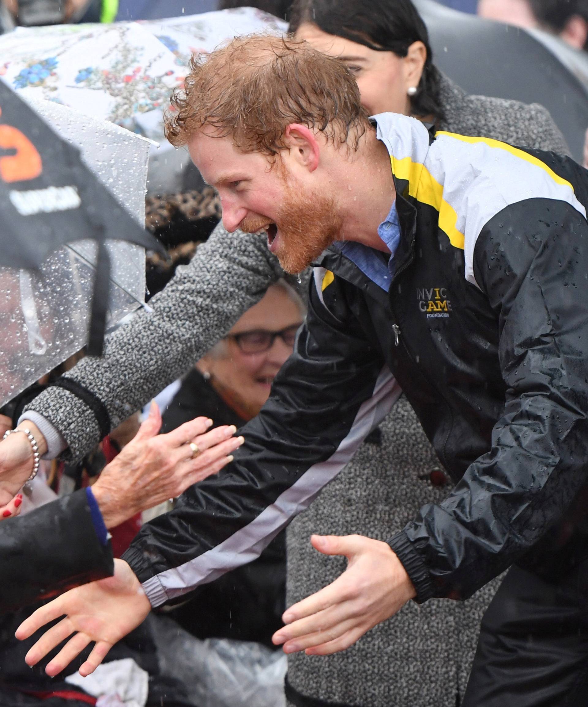 Britain's Prince Harry meets Daphne Dunne during a walk around The Rocks district of Sydney with New South Wales Premier Gladys Berejiklian