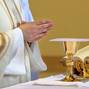 Chalice on the altar and priest celebrating mass in the background and empty space for text
