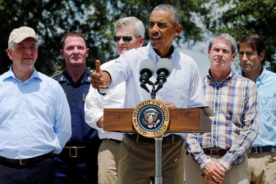 U.S. President Barack Obama, flanked by elected officials including Louisiana Governor John Bel Edwards delivers remarks after touring a flood-affected neighborhood in Zachary