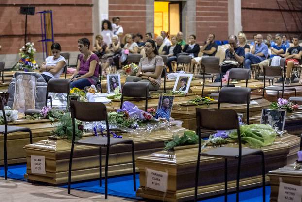 Coffins of some of the victims of the earthquake in central Italy are seen inside a gym in Ascoli Piceno