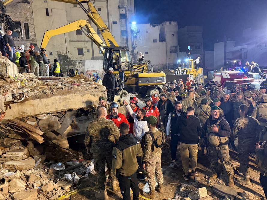 Rescue teams search for survivors after a building collapsed in Tripoli
