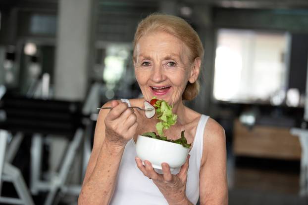 Senior woman eating healthy salad. elderly health lifestyle conc