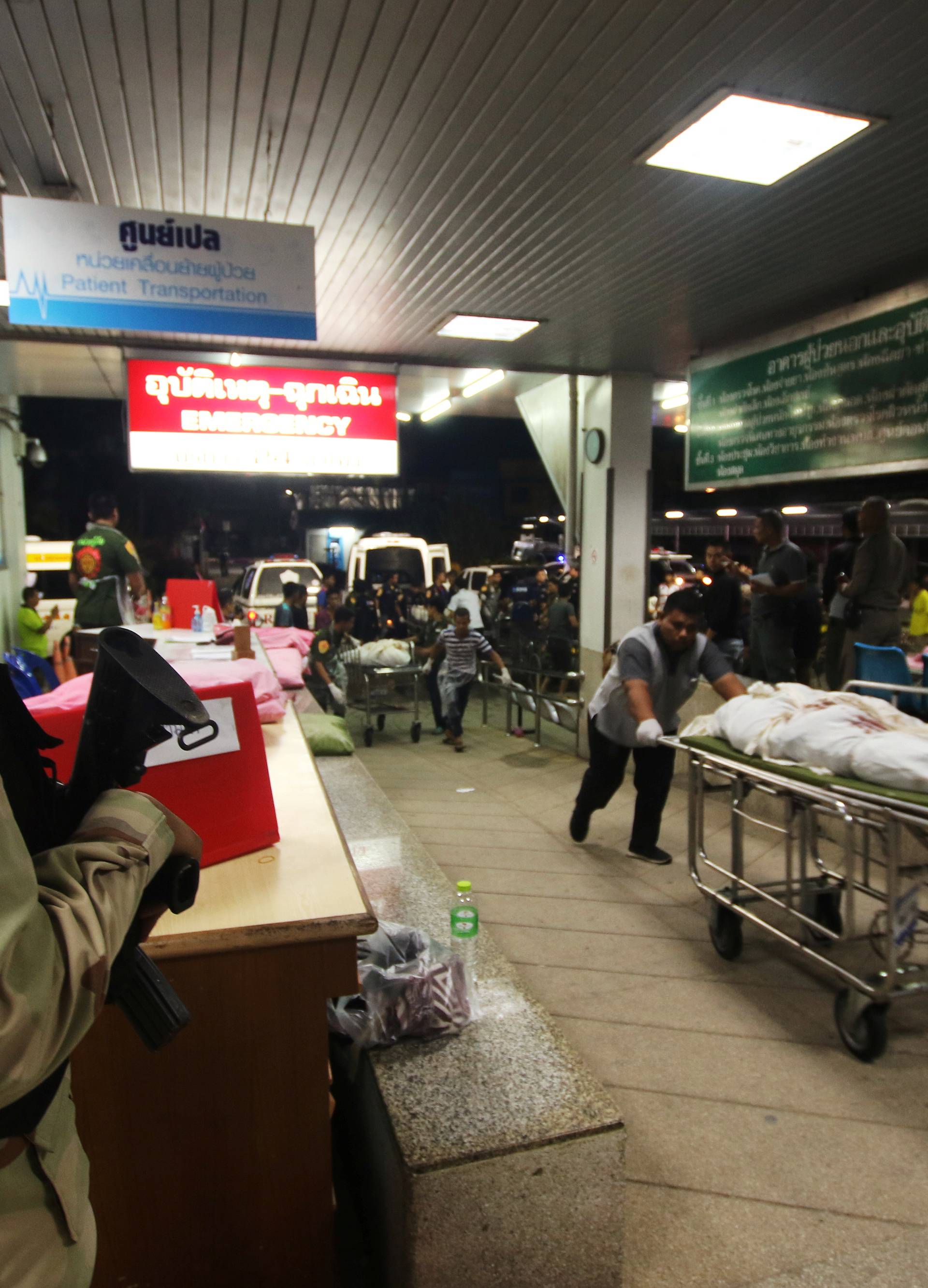 Rescue workers push stretcher trolleys carrying the bodies of dead village defence volunteers, who were killed by suspected separatist insurgents, at a hospital in Yala province