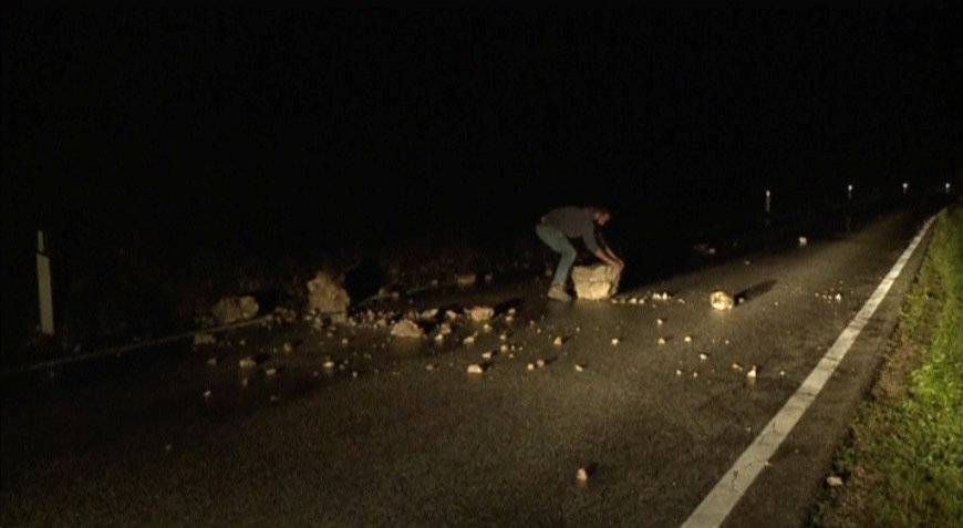 Still image from video shows a man trying to remove rubble from a road after an earthquake in Visso