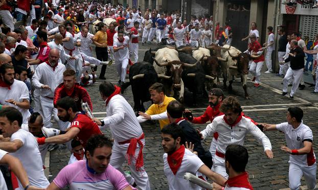 Runners sprint ahead of Fuente Ymbro fighting bulls during the fourth running of the bulls at the San Fermin festival in Pamplona