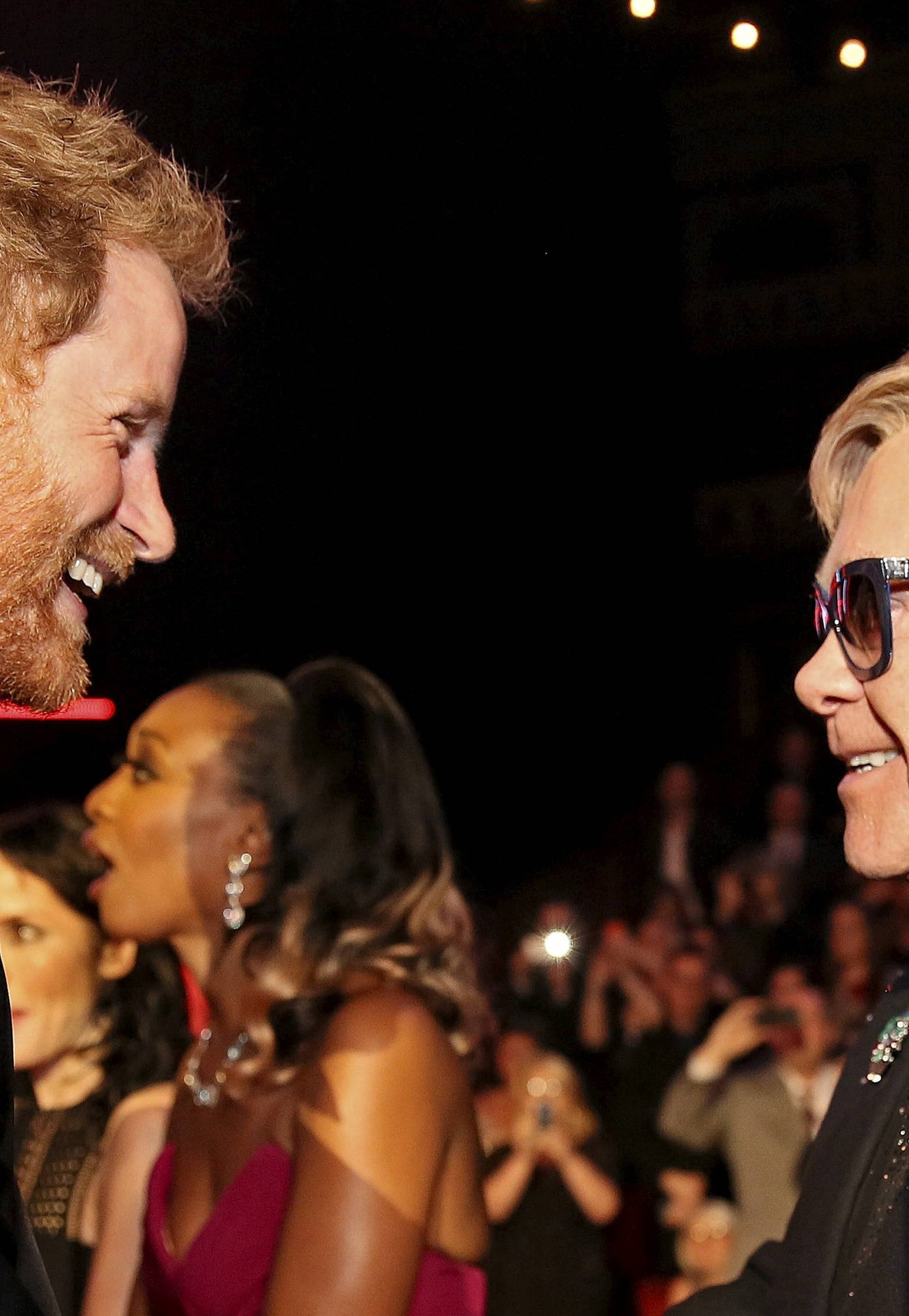 FILE PHOTO: Britain's Prince Harry greets Elton John after the Royal Variety Performance at the Albert Hall in London